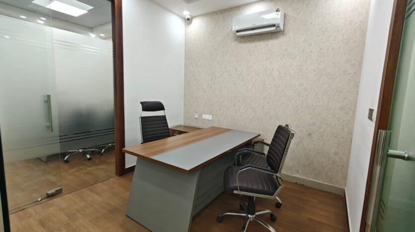 Air-conditioned office cabin with desk and chairs in Noida Sector 65